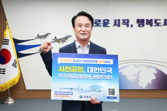 박동식 사천시장이 사천공항 국제공항 승격을 위한 홍보용 피켓을 들고 있다. 사진=사천시