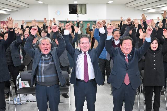 대구 군부대 군위 이전이 최종 확정된 후 김진열 군위군수(가운데) 등 군위 군민들이 손을 맞잡고 환호하고 있다.
