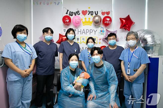 지난 18일 경기 고양시 건강보험 일산병원에서 열린 한 모양의 퇴원 축하 행사에서 한 양의 부모(가운데)와 병원 관계자들이 기념촬영을 하고 있다. (건보 일산병원 제공, 재판매 및 DB금지)