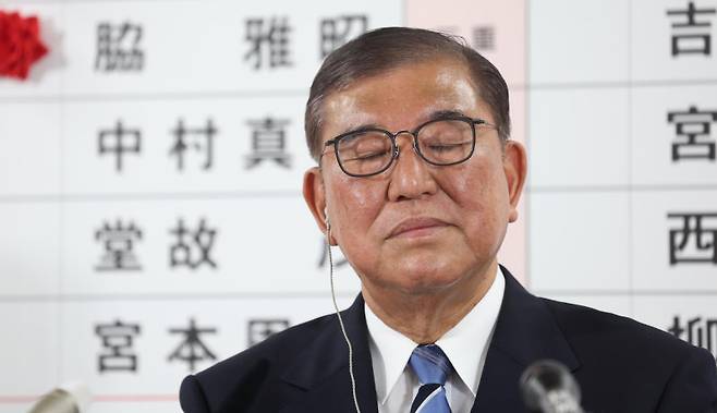 20일 일본 도쿄 자민당사에 차려진 개표 상황판 앞에서 이시바 시게루 총리가 자신의 거취를 묻는 취재진 질문에 눈을 질끈 감고 있다. 아사히신문 제공