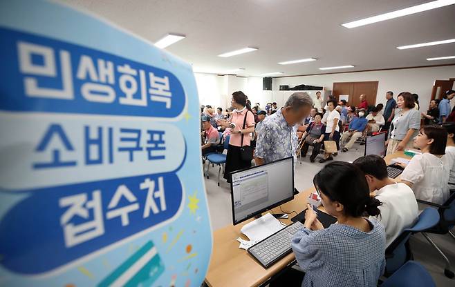 민생회복 소비쿠폰 지급 첫날인 21일 광주 북구 두암3동 행정복지센터에서 주민들이 신청절차를 밟고 있다. 연합뉴스.