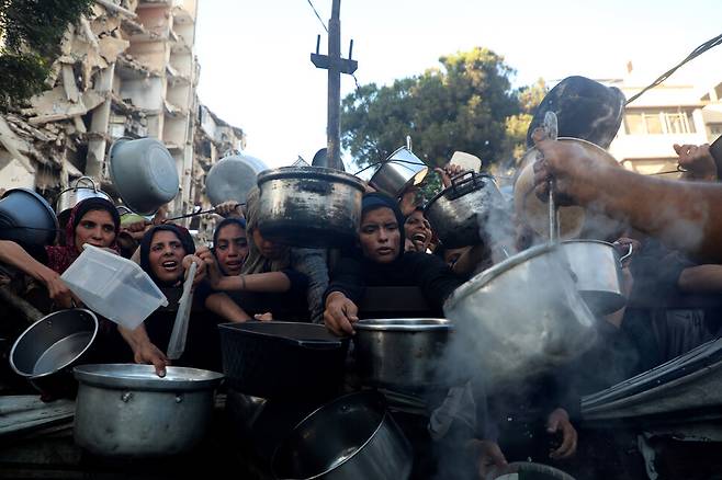 20일(현지시각) 팔레스타인인들이 가자북부 가자시티 중심부 리말 지역에서 식량을 받기 위해 기다리고 있다. 가자시티/신화 연합뉴스