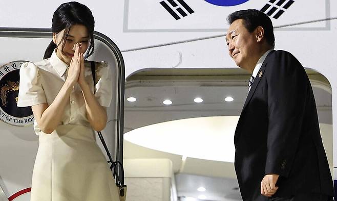 2022년 11월13일 오후(현지시각) 캄보디아 프놈펜 공항에서 비행기에 오르며 마중나온 인사들을 향해 인사하고 있는 윤석열 전 대통령과 부인 김건희 여사. 프놈펜/윤운식 선임기자 yws@hani.co.kr