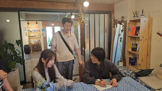 경남 남해 상주면에 있는 은모래마을책방에서 책에 사인하고 있는 와타나베 마리코.