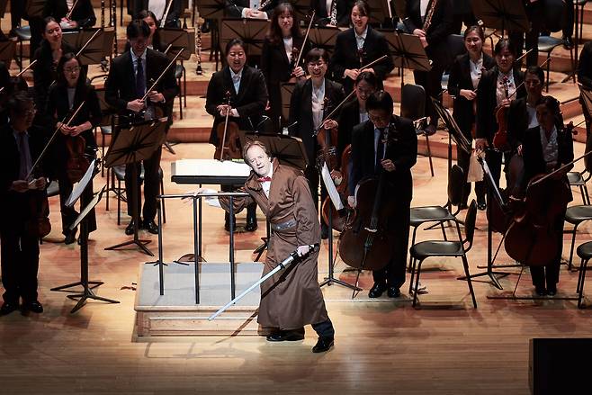 Conductor Anthony Inglis appears in a Jedi robe with a lightsaber during the inaugural "Hans Zimmer vs. John Williams" concert in 2018 at Lotte Concert Hall in Seoul. (Lotte Concert Hall)