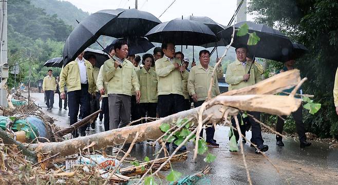 President Lee Jae Myung, right, inspects damages after torrential rainfall in a visit to Sancheong County, South Gyeongsang, on July 21. [JOINT PRESS CORPS]