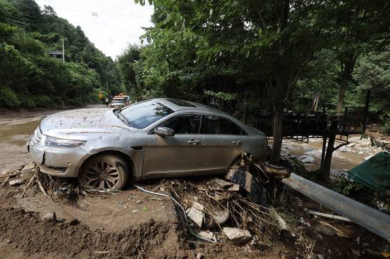 A car is seen submerged in mud as a landslide triggered by heavy rainfall swept the region in Mail-ri, Jojong-myeon, Gapyeong County, Gyeonggi, on July 21. [JUN MIN-KYU]