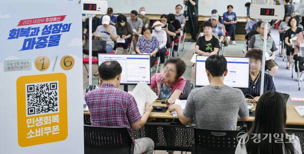 이재명 정부의 첫 대규모 경기 부양책인 '민생회복 소비쿠폰' 신청이 시작된 21일 오전 수원특례시 인계동 행정복지센터에서 시민들이 소비쿠폰을 신청하고 있다. 신청 첫 주인 21∼25일에는 시스템 과부하와 주민센터 혼잡 방지를 위해 출생 연도 끝자리 기준 요일제를 운영한다. 끝자리 1·6은 월요일, 2·7은 화요일, 3·8은 수요일, 4·9는 목요일, 5·0은 금요일에 신청할 수 있다. 주말에는 온라인 신청만 할 수 있다. 윤원규기자