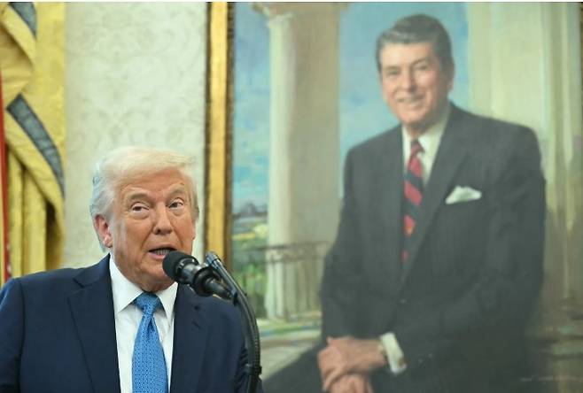 도널드 트럼프(왼쪽) 미국 대통령이 미국 워싱턴DC 백악관에 걸린 로널드 레이건 전 미국 대통령 초상화 앞에서 발언하고 있다.  [AFP]