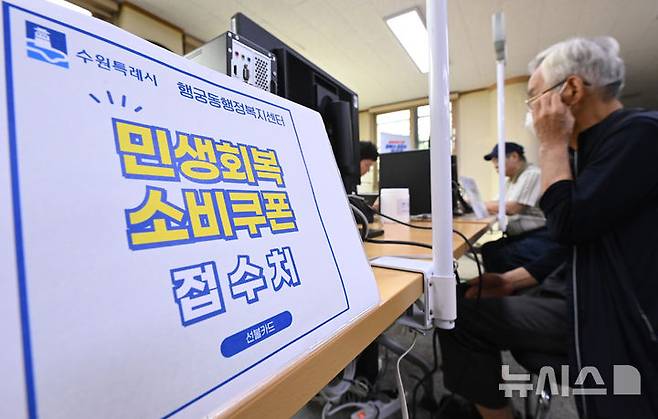 [수원=뉴시스] 김종택 기자 = 정부의 민생회복 소비쿠폰 1차 신청 첫날인 지난 21일 경기 수원시 행궁동 행정복지센터에서 시민들이 지원금을 신청하고 있다. 2025.07.21. jtk@newsis.com