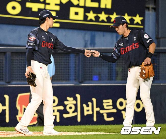 [OSEN=잠실, 이대선 기자] 19일 오후 서울 잠실야구장에서 2025 신한 SOL Bank KBO리그 LG 트윈스와 롯데 자이언츠의 경기가 열렸다.LG는 에르난데스, 롯데는 데이비슨을 선발 투수로 내세웠다.8회말 1사 1루에서 롯데 홍민기가 마운드를 내려가며 전민재에게 피치컴을 건네고 있다.  2025.07.19 /sunday@osen.co.kr