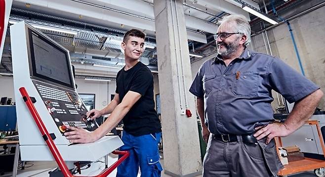 독일의 이원화된 직업교육은 기업과 학교의 유기적 협업으로 이루어진다. 고정밀 기계 기술을 배우는 도제생과 마이스터(장인)인 강사가 정밀공작기계인 CNC 밀링 패널 앞에서 현장 교육을 진행하고 있다. BIBB 제공