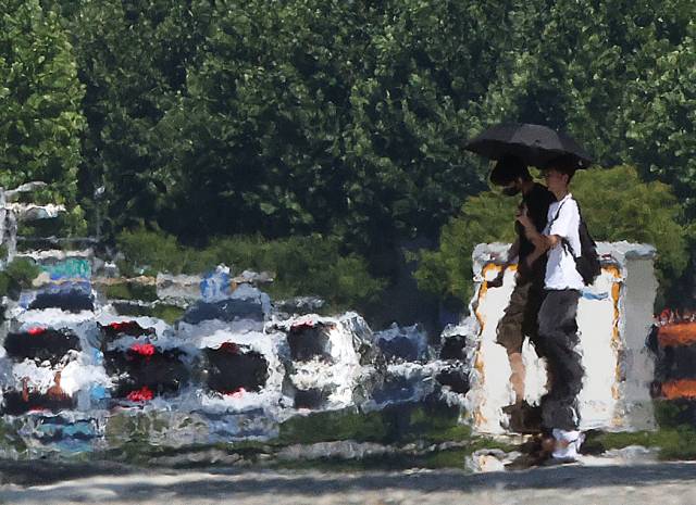 22일 대구 달서구 계명대학교 인근 도로가 지열로 달구어진 가운데 한 시민이 양산을 쓰고 이동하고 있다. 연합뉴스