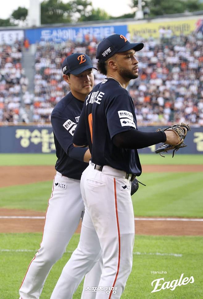 한화 문동주(왼쪽)이 22일 잠실 두산전에서 3회말 호수비를 펼친 리베라토를 기다려 고마워하고 있다. 한화이글스 제공