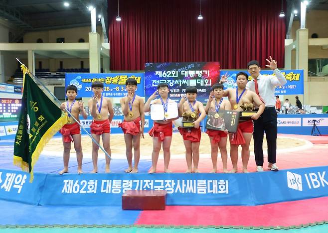 전라남도 장흥군 장흥실내체육관에서 열린 '제62회 대통령기전국장사씨름대회' 초등부 단체전 우승을 차지한 교방초등학교(경상남도)가 김현근 감독(오른쪽)과 함께 기념사진을 찍고 있다. /사진=대한씨름협회 제공