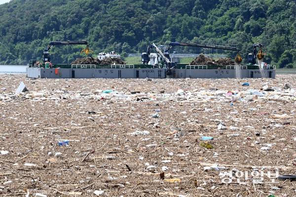 23일 오전 남양주시 팔당댐에서 경기도 수자원본부 관계자들이 장마기간 폭우로 팔당호에 떠밀려온 쓰레기를 수거하고 있다. 2025.7.23 /최은성기자 ces7198@kyeongin.com