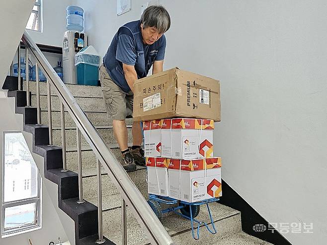 15일 오전 광주 남구 월산동 한 엘리베이터 없는 건물에서 택배 기사 김완씨가 40㎏에 달하는 물류를 실은 수레를 끌며 계단을 오르고 있다.