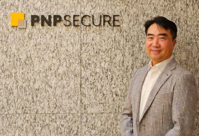 박천오 PNP시큐어 대표가 회사 CI를 배경으로 포즈를 취했다.