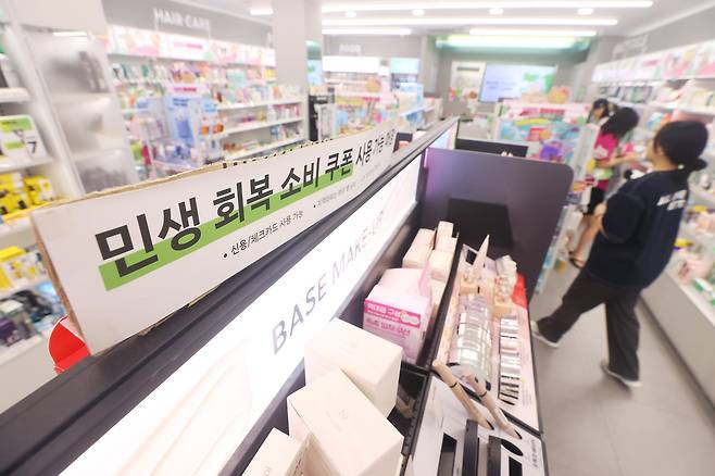 22일 서울 시내 한 화장품 소매점에 민생 회복 소비 쿠폰을 사용할 수 있다는 안내문이 놓여 있다. /연합뉴스