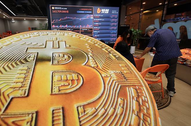 지난 18일 오후 서울 강남구 서초구 빗썸라운지 강남본점에서 비트코인 모형이 놓인 바닥에 코인 시세 그래프가 비치는 모습./뉴스1