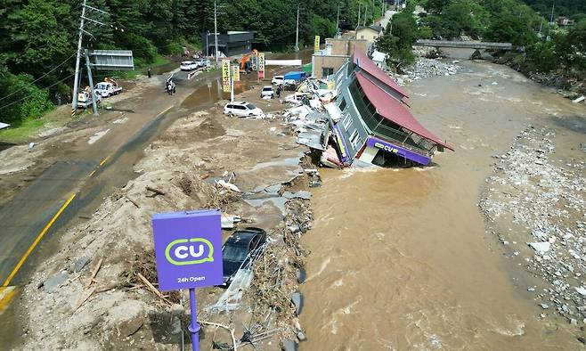 20일 내린 집중호우로 물이 넘치면서 경기도 가평군 조종면 현리 도로가 끊어지고 건물이 강 쪽으로 무너져내렸다. 류우종 기자 wjryu@hani.co.kr