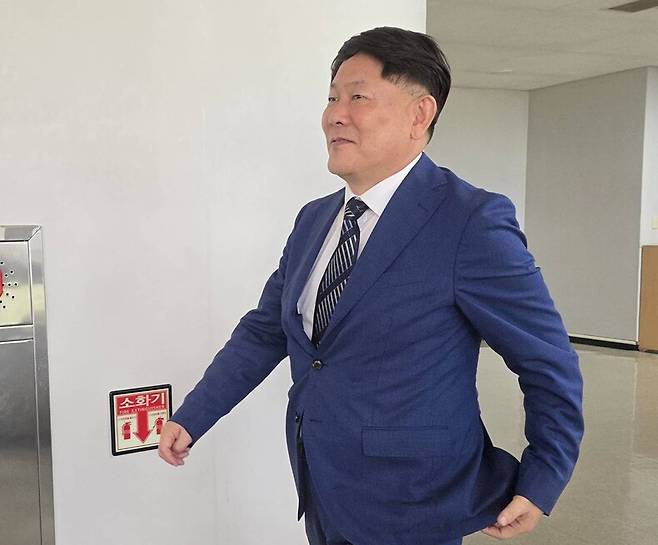 대리점 명의를 위장해 수십억원을 탈세한 혐의로 재판에 넘겨진 김정규 타이어뱅크 회장이 23일 항소심 선고 전 대전고등법원 법정 쪽으로 웃으며 걸어가고 있다. 이날 김 회장은 징역 3년형을 선고받고 법정 구속됐다. 연합뉴스