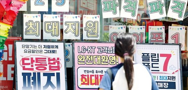 단말기 유통구조 개선에 관한 법률(단통법) 폐지 첫날인 22일 한 시민이 휴대폰 매장의 홍보 문구를 살펴보고 있다.  뉴스1