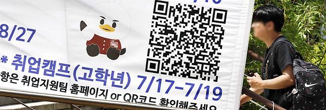 22일 서울의 한 대학 캠퍼스에 걸려 있는 취업지원 안내 현수막 앞으로 대학생이 걸어가고 있다.  김호영 기자
