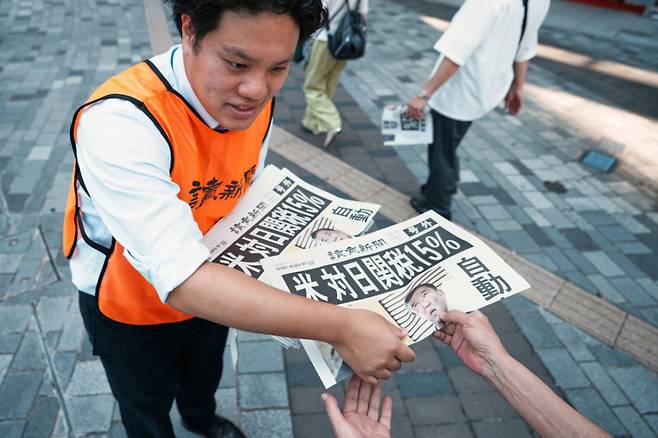 23일 일본 도쿄에서 요미우리 신문사의 한 직원이 도널드 트럼프 미국 대통령이 일본과 무역 협상을 완료했다는 내용을 보도한 신문 호외판을 배포하고 있다. 신문 1면에는 '미국, 일본에 15% 관세'라는 제목의 기사가 실렸다. /AP=뉴시스