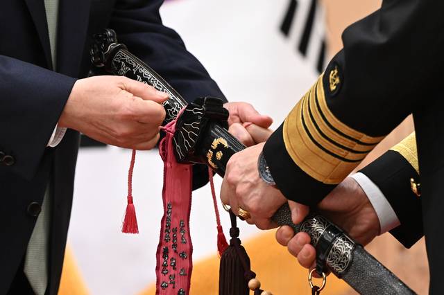 윤석열 전 대통령이 지난 2023년 10월 30일 서울 용산 대통령실 청사에서 열린 장성 진급·보직 신고 및 삼정검 수치 수여식에서 양용모 해군 참모총장의 삼정검에 수치를 직접 매어주는 모습. 대통령실 제공