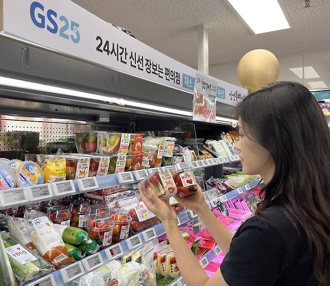 편의점 GS25를 찾은 소비자가 소용량 과일 판매대에서 제품을 살펴보고 있다.   [GS25 제공]