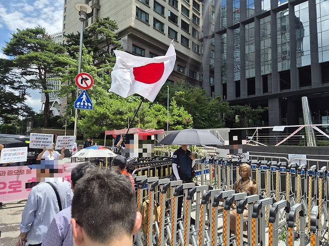 23일 오후 12시께 서울 종로구 옛 주한일본대사관 앞 ‘평화의 소녀상’ 부근에서 위안부법폐지국민행동, 국민계몽운동본부 등이 ‘일본군 위안부 피해가 거짓’이라 주장하는 집회를 열었다. 집회참가자가 일장기를 흔들고 있다. 김도윤 기자.