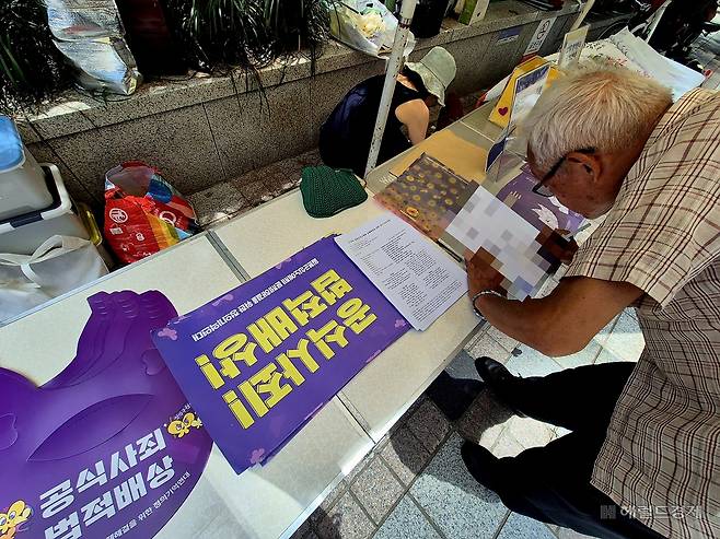 23일 오후 12시께 평화의 소녀상 인근에서 정의기억연대(정의연)의 1710차 정기 수요시위가 열렸다. 한 시민이 참가자 명단에 서명하고 있다. 김도윤 기자.