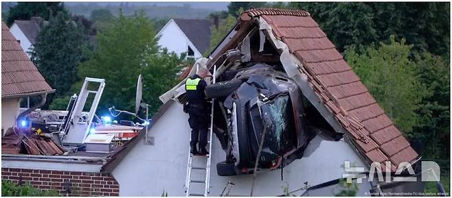 [뉴시스]가정집 창고 지붕에 처박힌 차량 모습. (사진=도이치벨레, NordwestmediaTV)