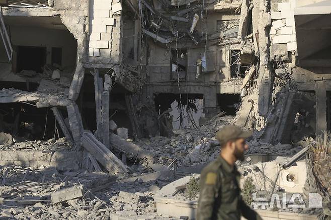 [다마스쿠스=AP/뉴시스] 지난 16일(현지 시간) 시리아 다마스쿠스에서 한 군인이 이스라엘의 공습으로 파손된 것으로 알려진 시리아 국방부 청사 앞을 지나가고 있다. 2025.07.23.