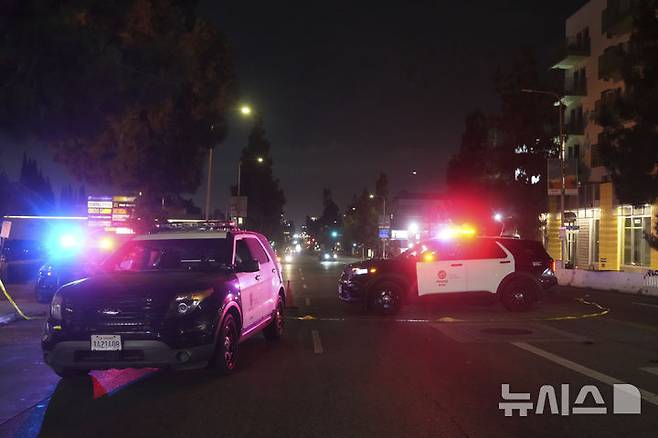 [로스앤젤레스=AP/뉴시스]  19일 주말새벽에 일어난 로스앤젤레스의 버몬트 나이트클럽 앞 차량 돌진 사건 현장에서 경찰 순찰차량들이 인도의 인파 속으로 일부러 돌진한 사고 경위를 조사하고 있다.  2025.07.23.