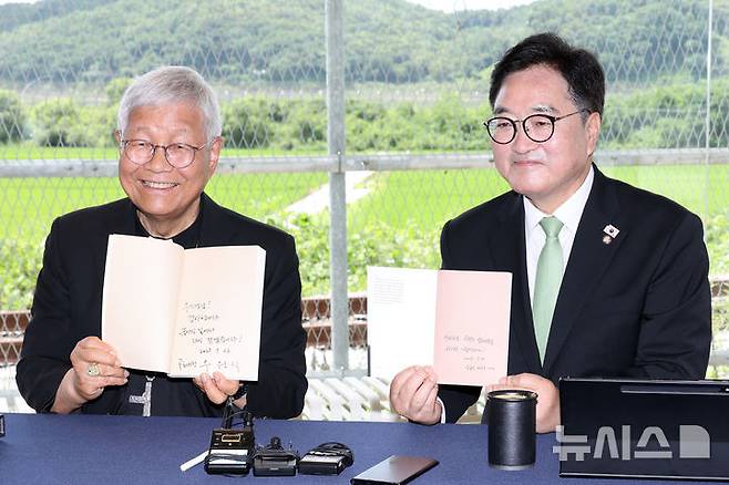 [파주=뉴시스] 국회사진기자단= 우원식 국회의장과 유흥식 추기경이 23일 경기도 파주 임진각 평화누리공원 한 카페에서 서로의 저서를 들고 기념촬영을 하고 있다. 2025.07.23. photo@newsis.com