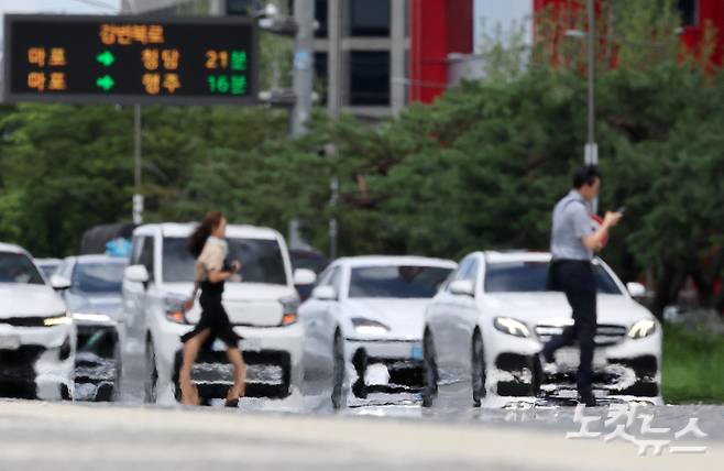 폭염으로 아지랑이가 피어오르는 도로를 시민들이 지나고 있다. 박종민 기자