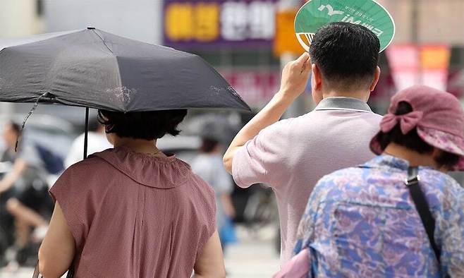 지난 4일 대구 수성구 달구벌대로에서 시민들이 양산과 부채로 뙤약볕을 가리고 있다. 대구=뉴스1