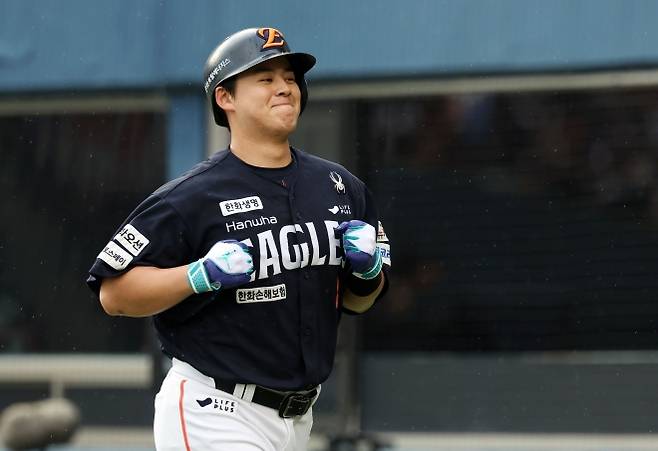 프로야구 한화 이글스 노시환이 22일 서울 잠실야구장에서 열린 두산 베어스와의 경기에서 2회 1점 홈런으로 선취점을 뽑아낸 뒤 웃으며 더그아웃으로 뛰어가고 있다.  뉴시스