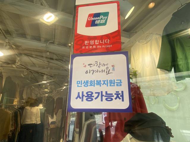 의류 잡화점 문 앞에 '소비쿠폰 사용처' 스티커가 붙어있다. 사진= 최혜빈 인턴기자