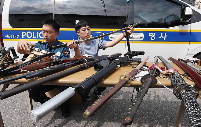 지난해 경기도 수원남부경찰서에서 범죄예방질서계 경찰관들이 보관 중인 불법무기 등을 살펴보고 있다. ⓒ연합뉴스