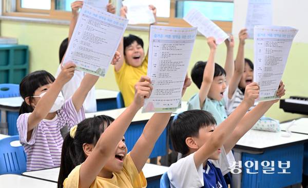 24일 오전 수원시 팔달구 매산초등학교에서 여름 방학식을 마친 학생들이 안내문을 들어 보이며 기뻐하고 있다. 2025.7.24 /임열수기자 pplys@kyeongin.com