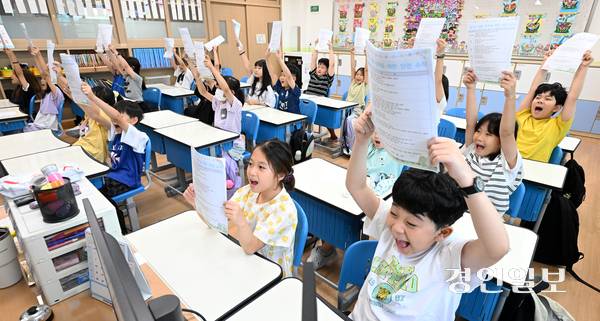 24일 오전 수원시 팔달구 매산초등학교에서 여름 방학식을 마친 학생들이 안내문을 들어 보이며 기뻐하고 있다. 2025.7.24 /임열수기자 pplys@kyeongin.com