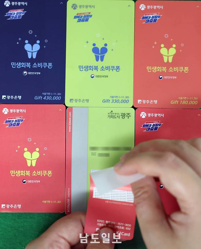민생회복 소비쿠폰 색상 교체24일 광주광역시 동구의 한 행정복지센터에서 공무원들이 소비쿠폰 현물카드에 스티커를 붙여 색상을 교체하고 있다. 광주시는 소득수준별 소비쿠폰 현물 카드 색상을 달리해 인권 감수성이 부족하다는 지탄을 받았고, 공무원들의 철야 작업으로 스티커를 붙여 색상을 통일했다. 위쪽 사진은 기존 소비쿠폰 현물 카드. /임문철 기자 35mm@namdonews.com