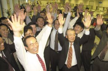 2000년 12월 15일, IMT2000 사업권 획득 소식에 당시 조정남 SK텔레콤 부회장(앞줄 오른쪽) 등 임직원들이 환호하고 있다.