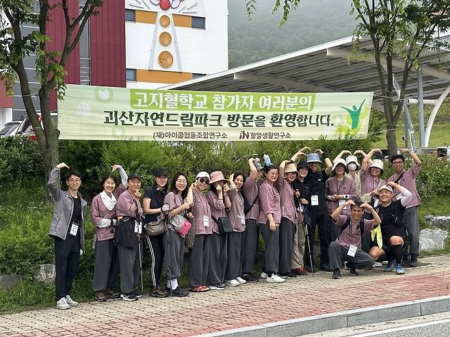 총 5회에 걸쳐 괴산자연드림파크에서 진행된 ‘고지혈학교 클린캠프’ 중 지난 6월26일부터 1박2일로 참가한 3회차 참가자들이 환영 플래카드 아래에서 밝게 웃고 있다. 고지혈학교 프로그램에는 고지혈 관리에 도움이 되는 식이 와 운동 등 생활실천방법을 체험형으로 배우는 1박2일 고지혈학교 클린캠프가 필수 과정이다.