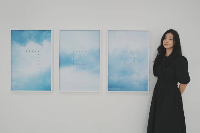 문선희 작가가 광주 양림미술관에서 열린 사진전 '친애하는 구구씨'에서 작품을 배경으로 사진 촬영을 하고 있다. 문선희 작가 제공