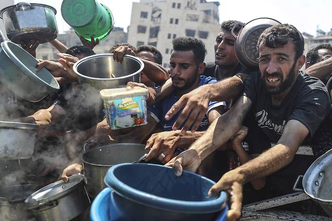23일 가자지구의 배급소에서 팔레스타인 군중들이 음식을 받기 위해 몰려들고 있다. UPI연합뉴스