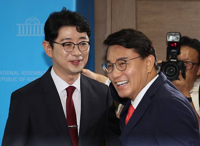 윤상현 국민의힘 의원(가운데)이 24일 서울 여의도 국회 소통관에서 국민의힘 당대표 출마 선언 기자회견을 한 주진우 의원(왼쪽)을 만나 인사하고 있다. [사진 출처 = 연합뉴스]